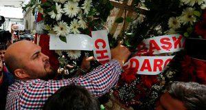 Een rouwende trekt krans waar naam kilicdaroglu op staat af tijdens begrafenis politieagent die sneuvelde tijdens de aanslag op een politiebus in Istanbul op juni