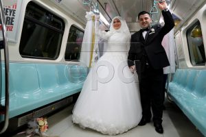 epa05609545 Alper Odabas (C-R) and Yesim Demiray (C-L) on the subway to travel to their wedding ceremony at another Istanbul Subway in Istanbul, Turkey, 30 October 2016. The Istanbul Metropolitan Municipality announced that it will allow subway stations to be used as venues for wedding ceremonies.  EPA/TOLGA BOZOGLU